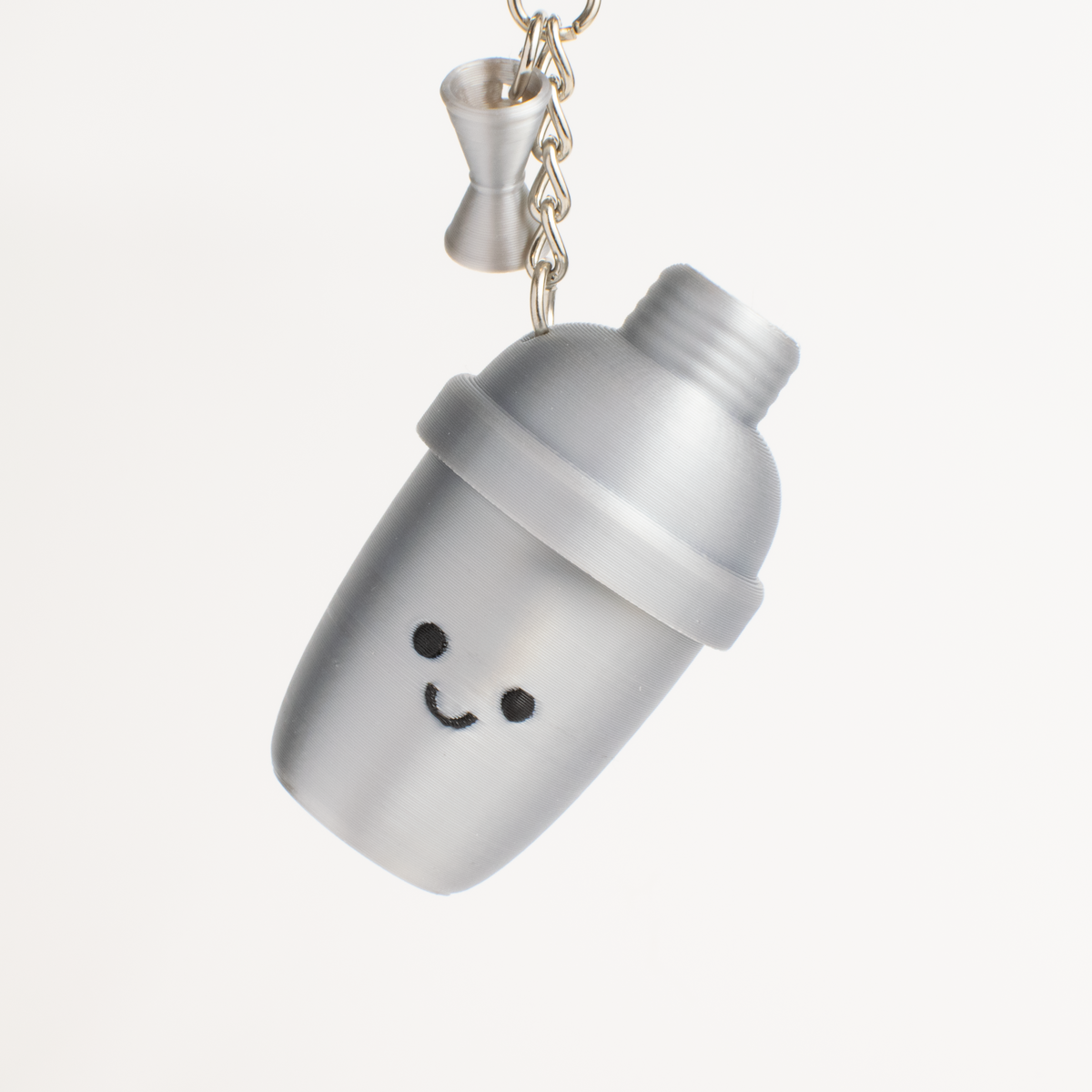 Cute cocktail shaker fidget clicker and shaker keychain hanging as a playful bag accessory