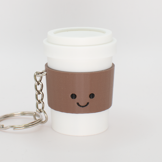 Cute coffee fidget clicker keychain with a mocha colored sleeve and smiling face