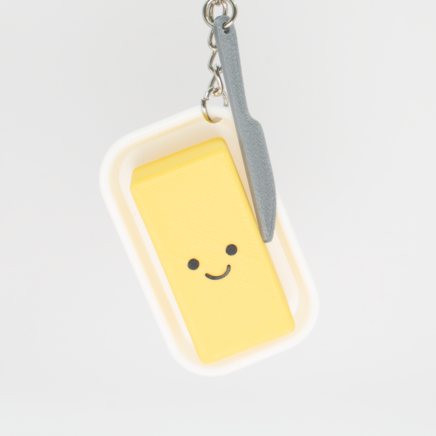 Cute creamy butter fidget clicker keychain with a smiling face