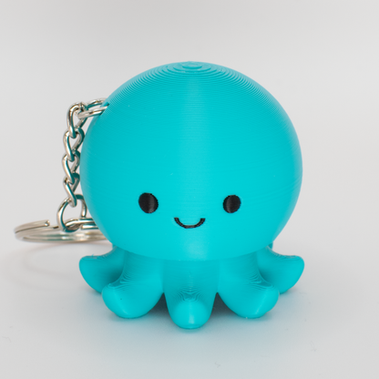 Turquoise octopus fidget clicker with a smiling face