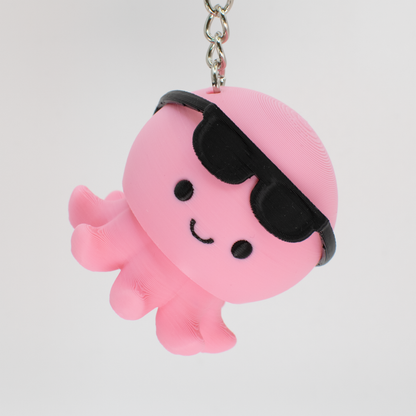 Cute pink octopus with sunglasses clicker keychain hanging as a fun bag charm or key accessory