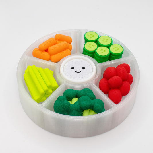 A colorful veggie platter clicker fidget toy with multiple switches (6) and a smiley face on a white background. There are carrots, cucumbers, cherry tomatoes, celery, broccoli, and a dipping sauce.