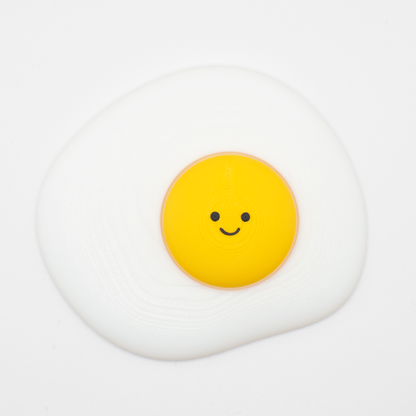 Cute fried egg fidget clicker desk buddy with a cheerful smile and clicky yolk