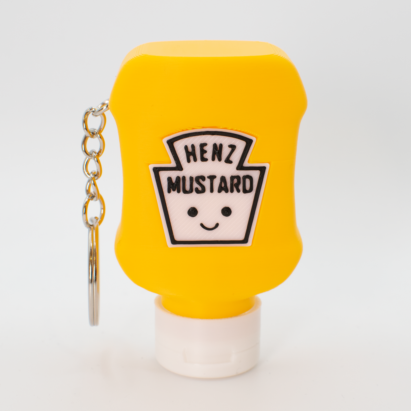 Yellow mustard bottle fidget clicker keychain with a smiley face label on a white background