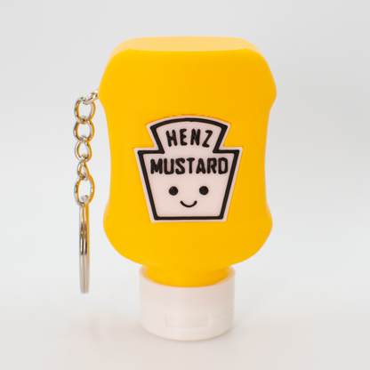 Yellow mustard bottle fidget clicker keychain with a smiley face label on a white background