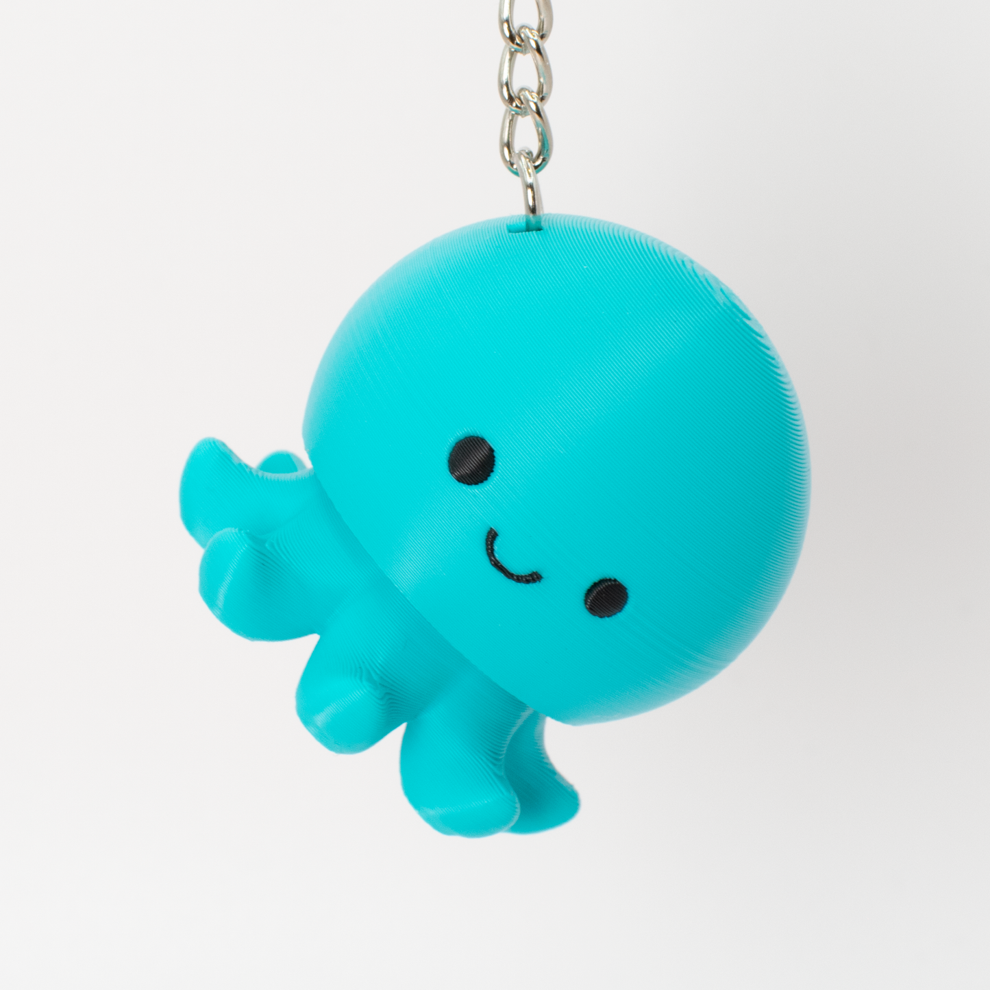 Turquoise octopus clicker keychain hanging as a fun bag charm or key accessory