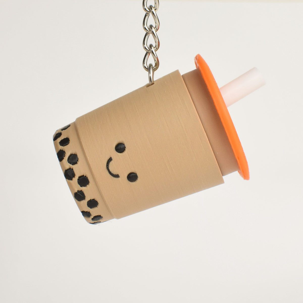 Keychain shaped like a bubble tea cup with a smiley face