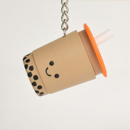 Keychain shaped like a bubble tea cup with a smiley face