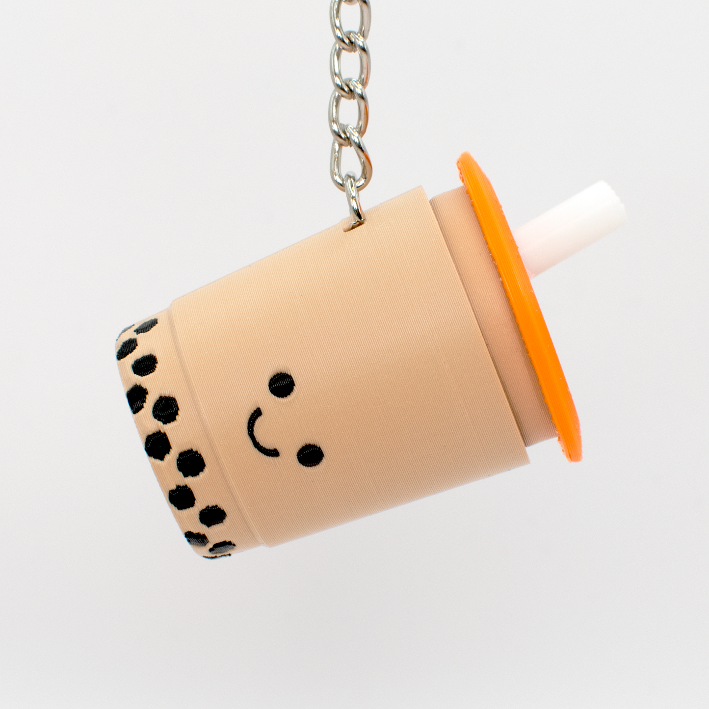 Keychain shaped like a bubble tea cup with a smiley face
