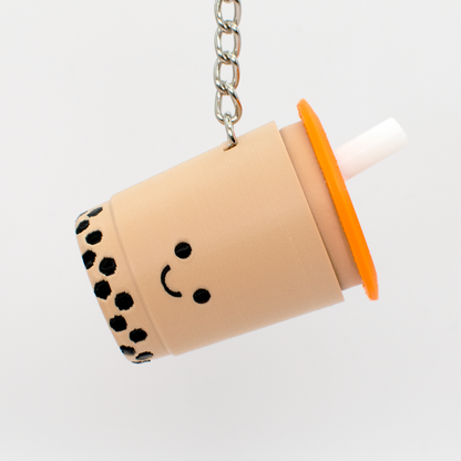 Keychain shaped like a bubble tea cup with a smiley face