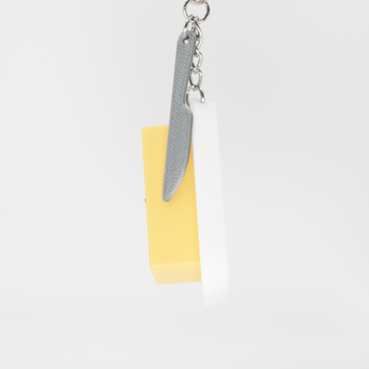 Side view of an original creamy butter fidget clicker keychain with a little knife