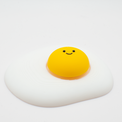 Side view of an original fried egg fidget clicker desk toy