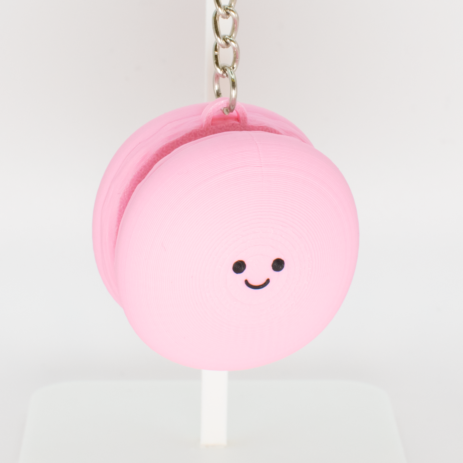Cute macaron fidget clicker keychain with a smiling face