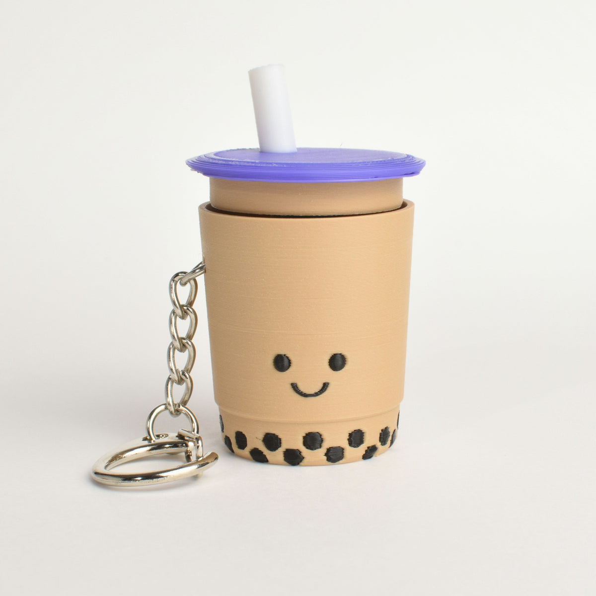 Cute bubble tea fidget clicker keychain with black boba pearls and a smiling face and a purple lid