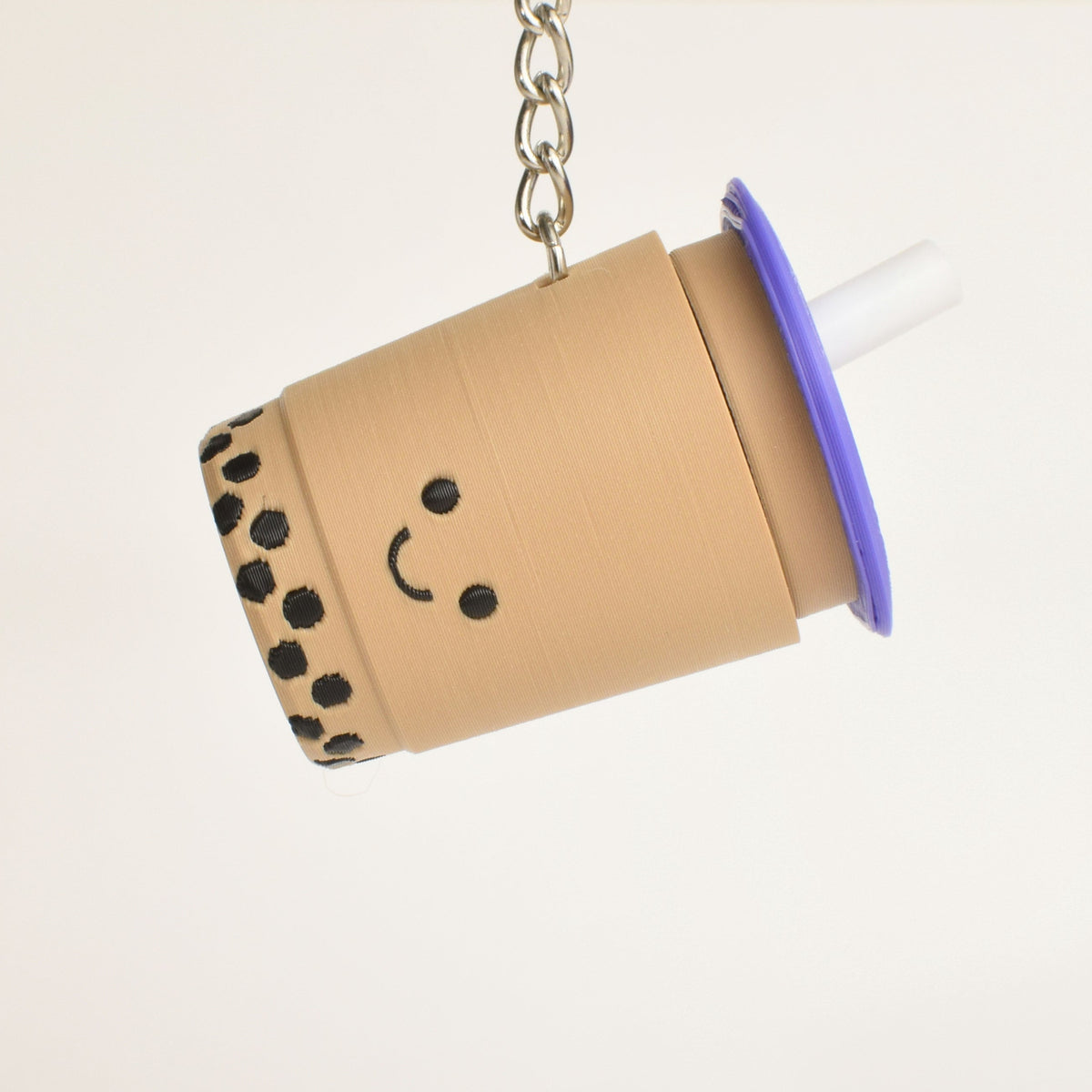 Bubble tea fidget clicker keychain with purple lid hanging as a cute bag charm or key accessory