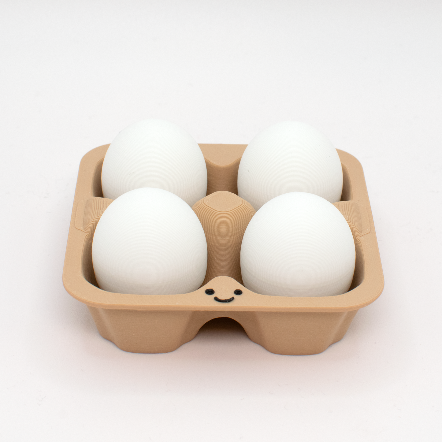 fidget clicker styled as a beige egg carton with four white eggs inside,  with a smiling face on the carton.