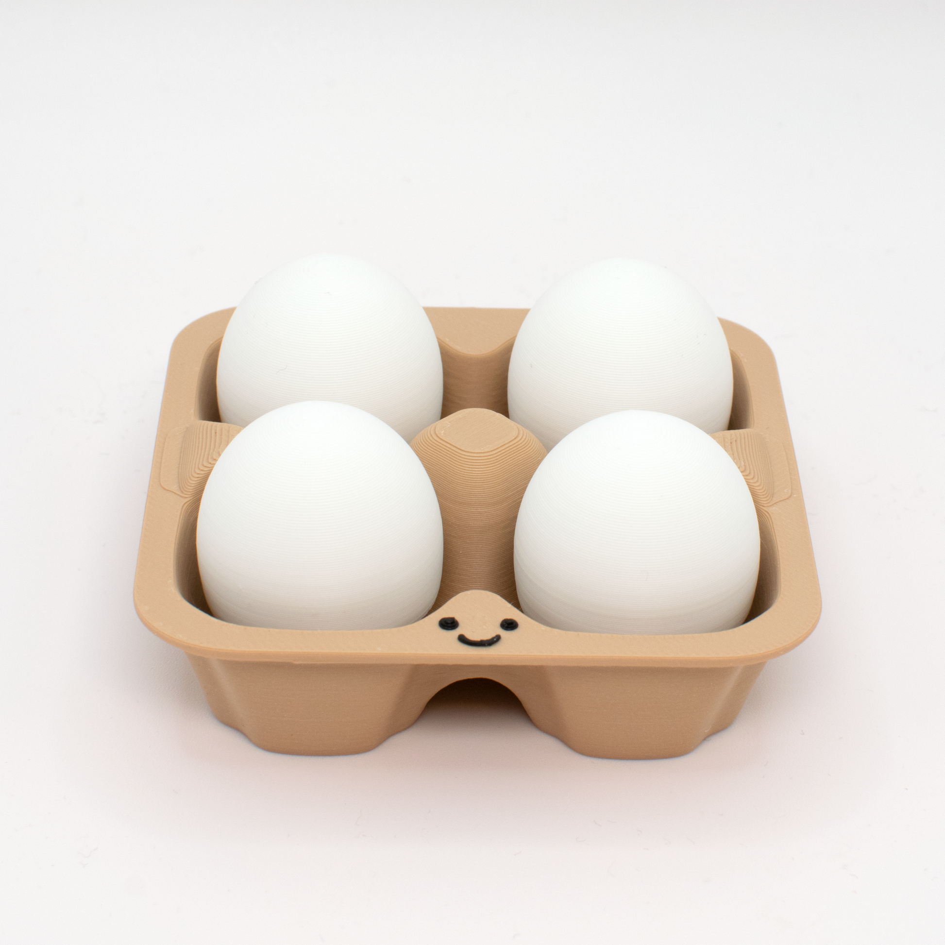 fidget clicker styled as a beige egg carton with four white eggs inside,  with a smiling face on the carton.