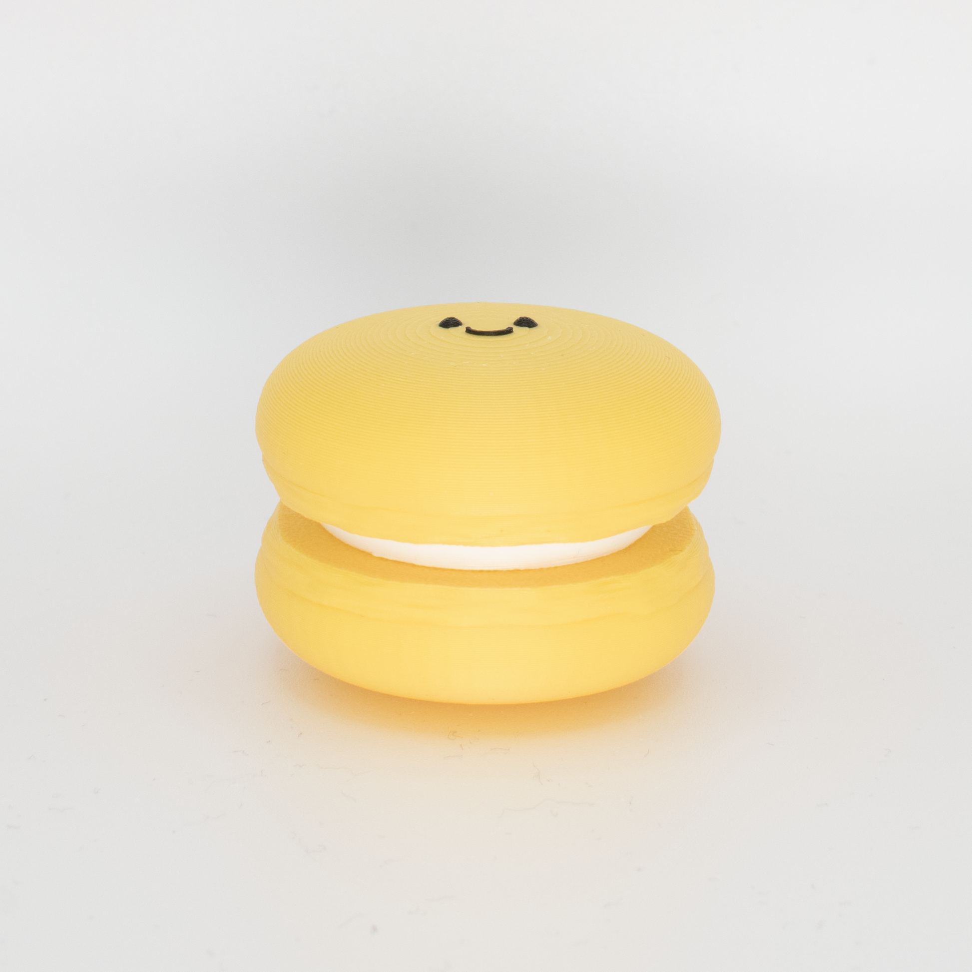 Side view of an original yellow macaron fidget clicker keychain