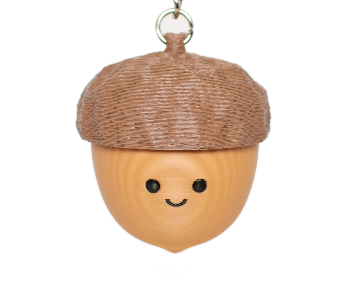 fidget clicker that looks like an acorn with the top clickable and a smiley face