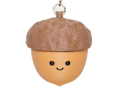 fidget clicker that looks like an acorn with the top clickable and a smiley face
