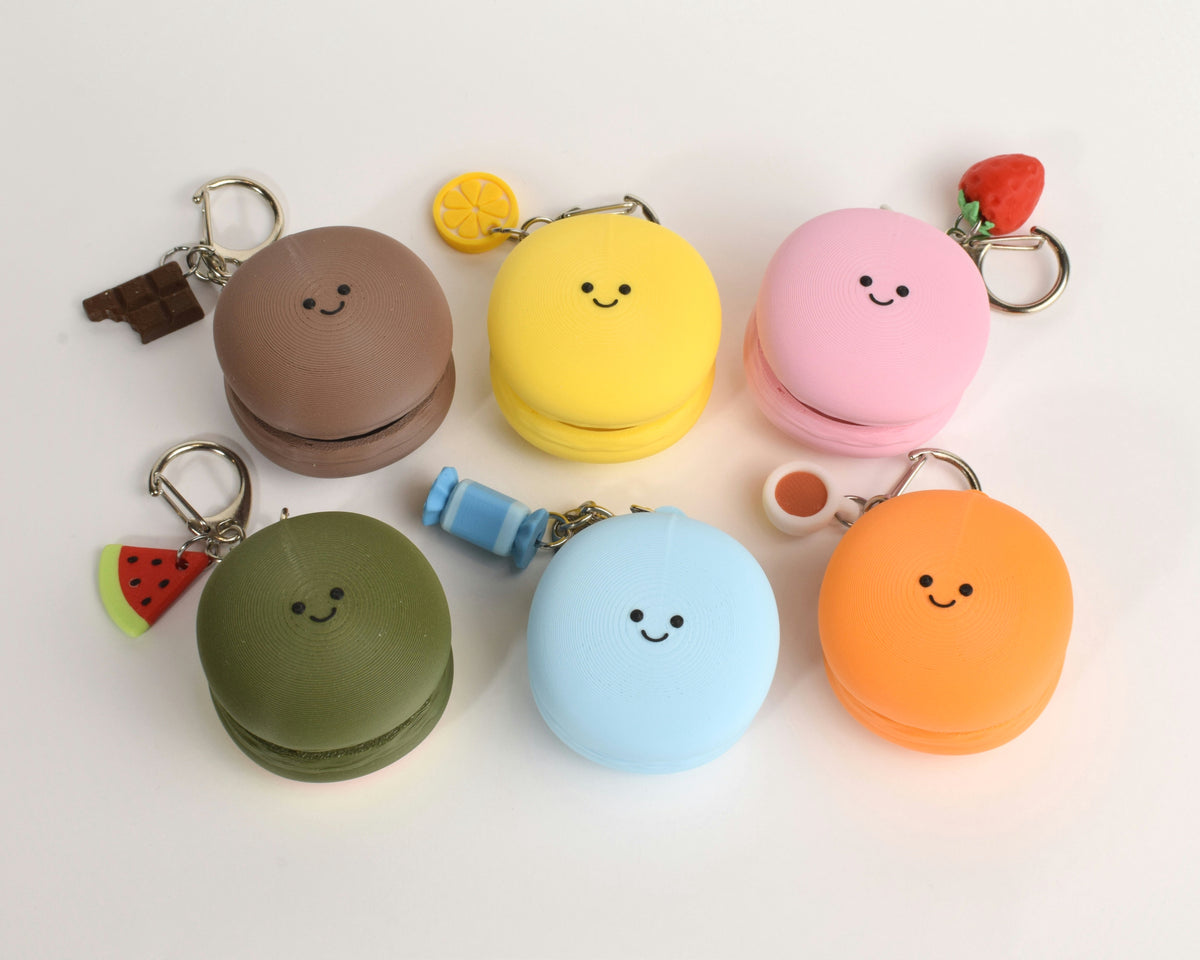 top view of the macaron clickers showing their smiley faces and the tiny charms