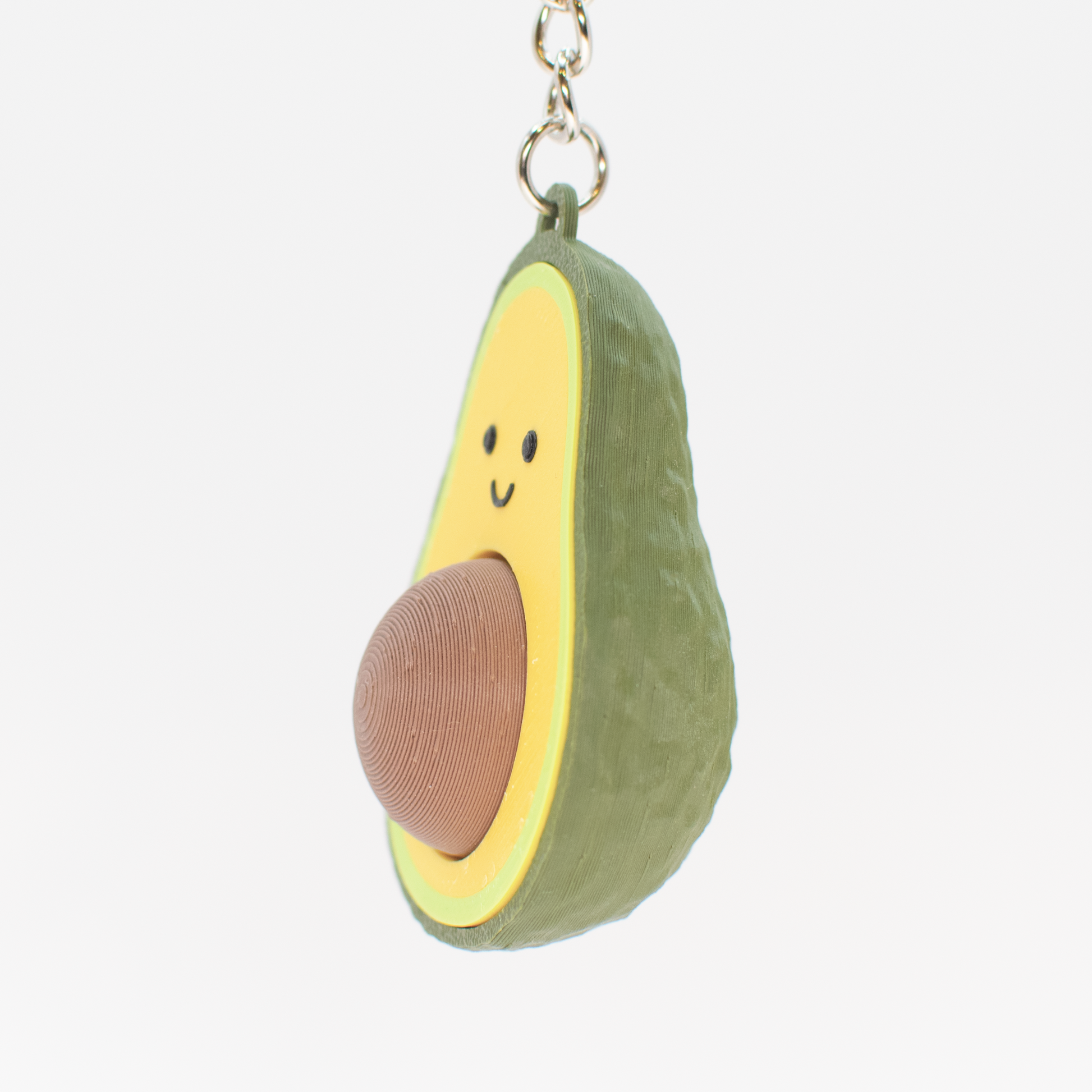 Avocado shaped fidget clicker keychain with a smiling face