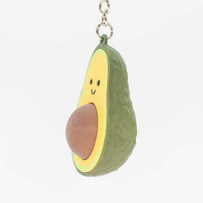 Avocado shaped fidget clicker keychain with a smiling face