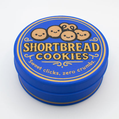 Blue tin lid with 'Shortbread Cookies' text and cute smiley cartoon cookies