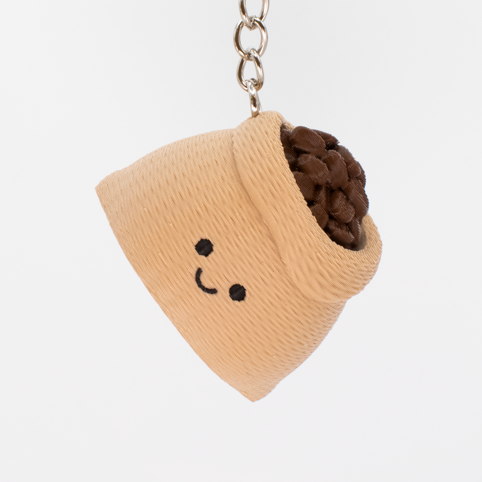 Keychain with a beige container holding brown coffee beans on a white background
