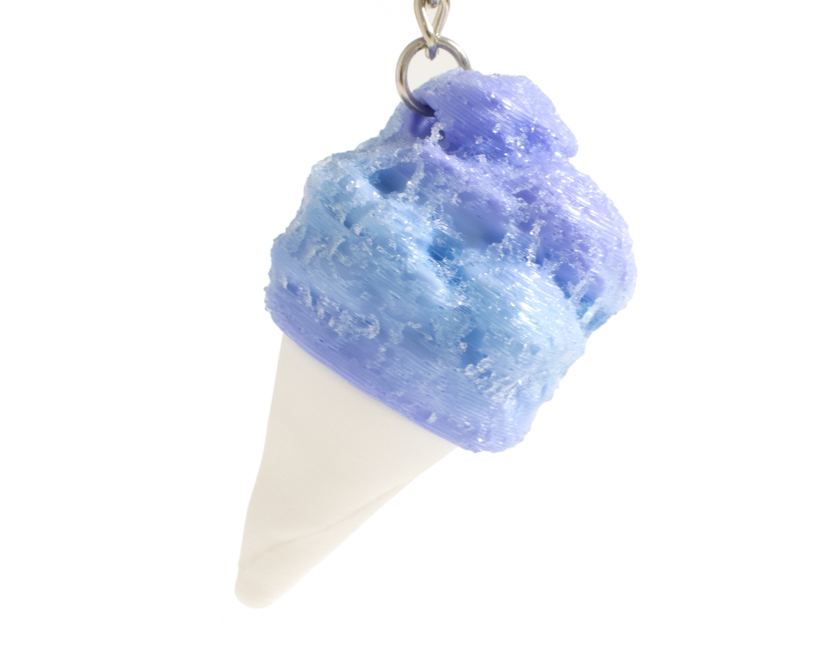 A cotton candy shaped fidget clicker, featuring a textured blue and purple swirled top and a white cone base, suspended from a silver metal chain against a plain white background.