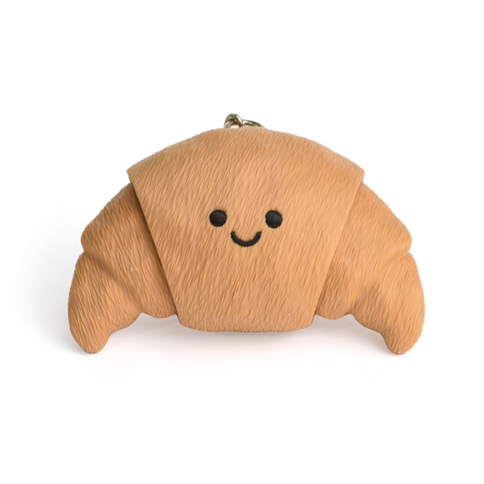 a cute croissant clicker keychain with smiley face, with two clickable ends