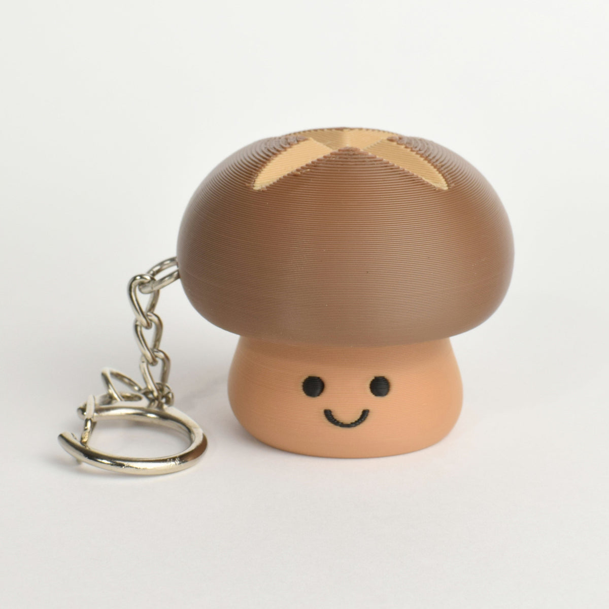 Cute brown mushroom clicker keychain with a smiling face