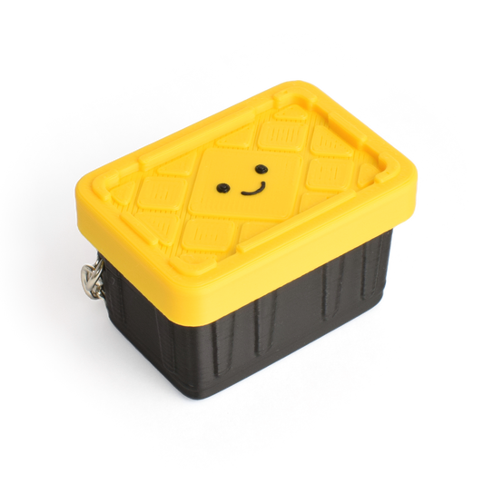 a cute yellow and black container fidget clicker with a smiley face