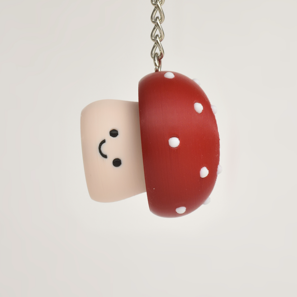Cute toxic mushroom clicker keychain with a smiling face hanging as a fun bag or key accessory