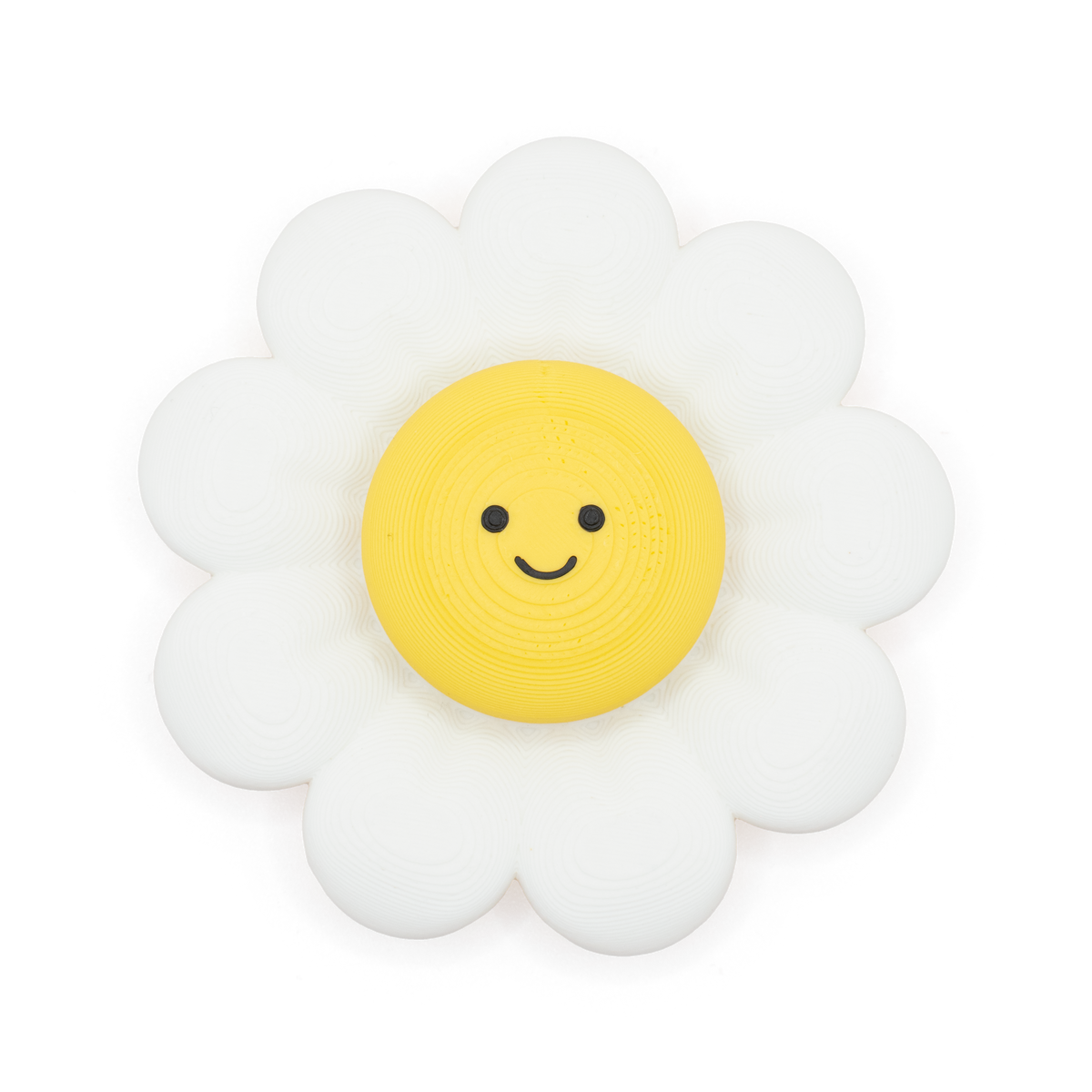 A daisy-shaped fidget spinner and clicker with a white outer petal ring and a yellow circular center featuring a simple black smiley face, shown on a plain white background.