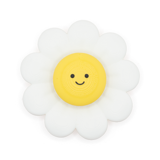 A daisy-shaped fidget spinner and clicker with a white outer petal ring and a yellow circular center featuring a simple black smiley face, shown on a plain white background.