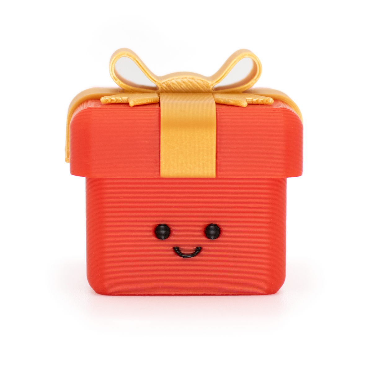 clicker styled as a small red gift box with a smiling face on the front, topped with a gold ribbon and bow, isolated on a white background.