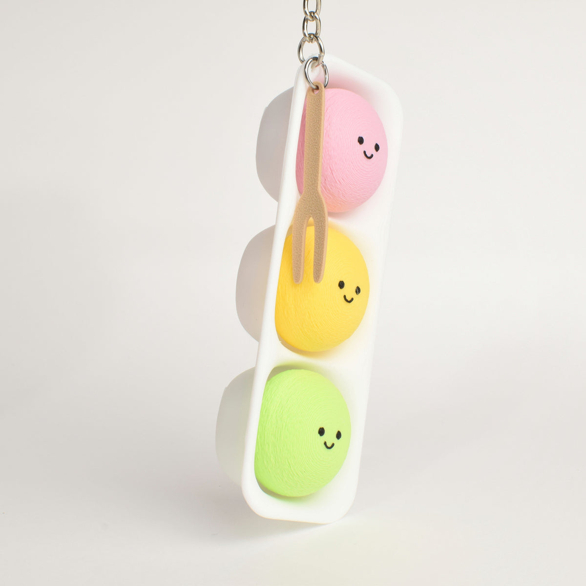 side view of a mochi ice cream clickers with three buttons and a fork