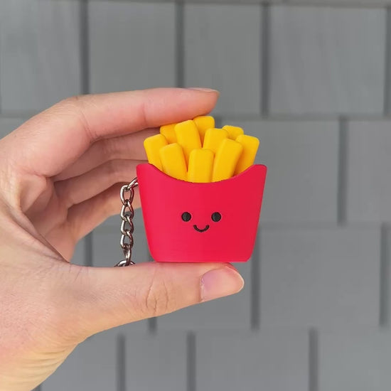 Hand clicking the cute French fries fidget toy for satisfying stress relief