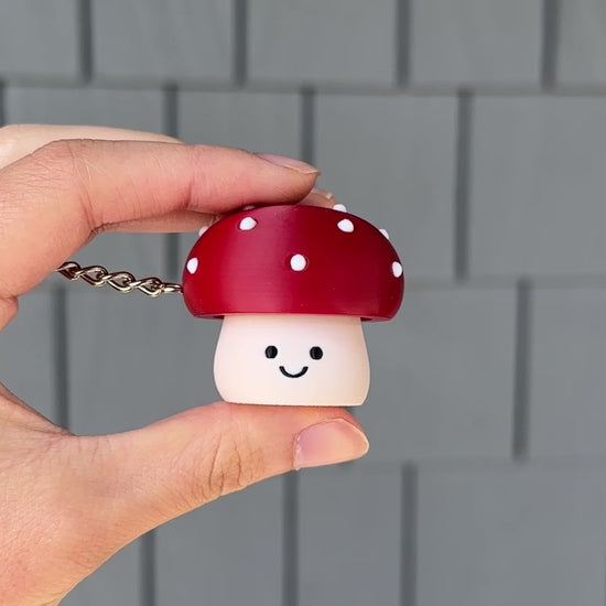 hand clicking a cute toxic mushroom fidget clicker keychain