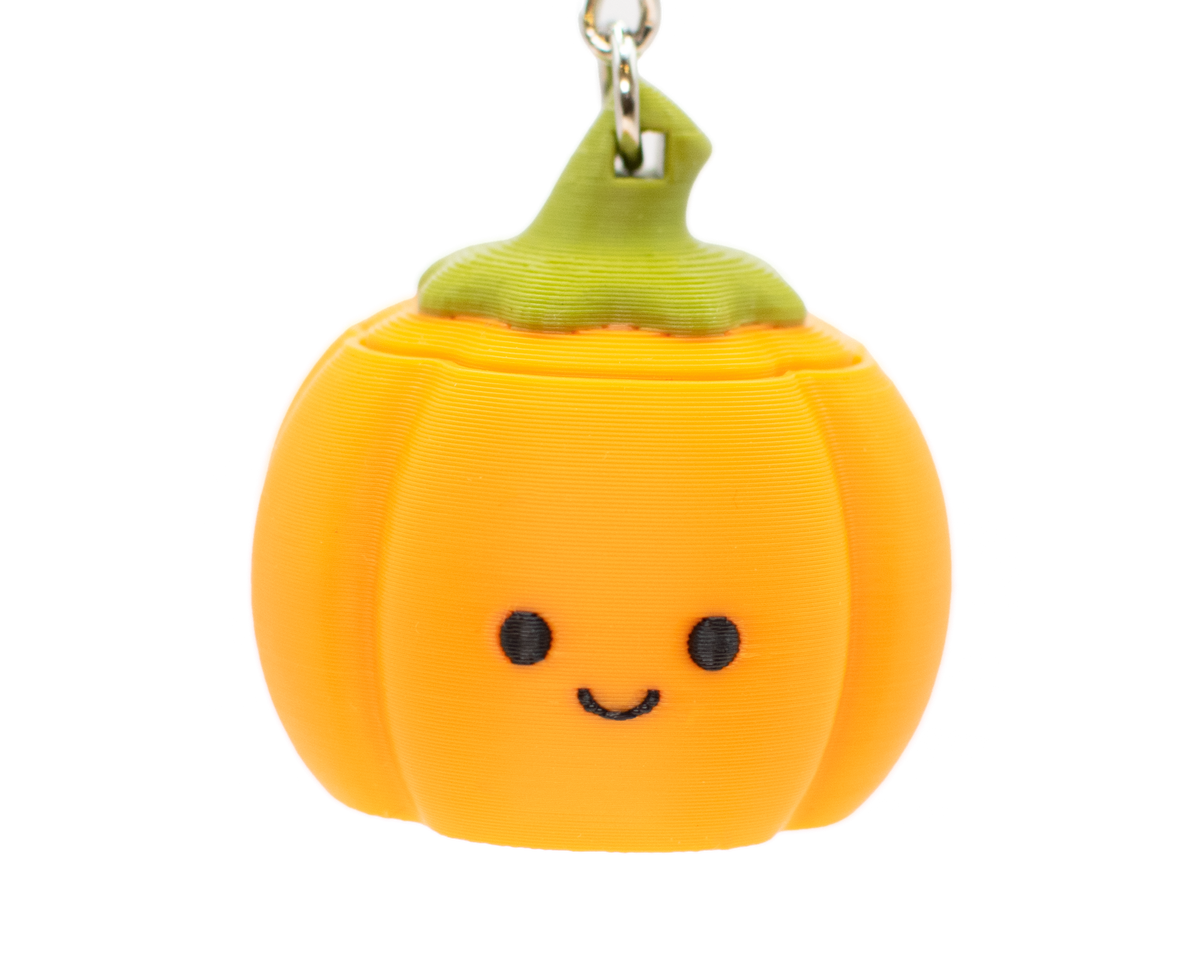 a cute pumpkin clicker keychain with a smiley face 