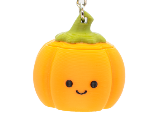 a cute pumpkin clicker keychain with a smiley face 