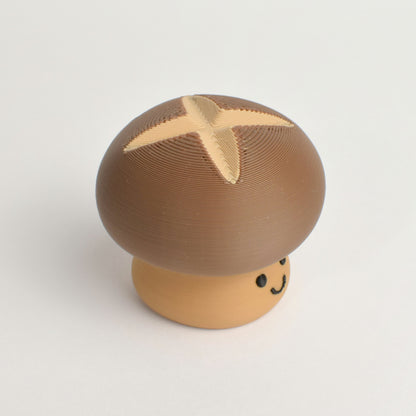 Top view of a brown mushroom clicker showing the round cap and cross