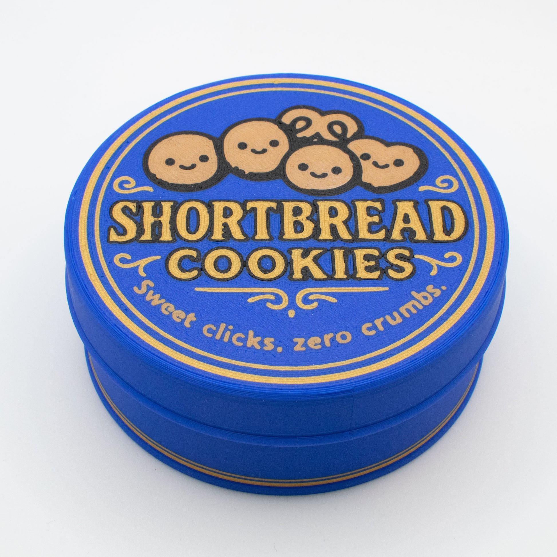 Blue tin lid with 'Shortbread Cookies' text and cartoon cookies with smiley faces on a white background