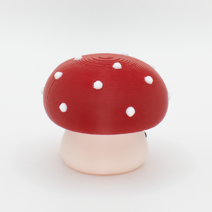 side view of a mushroom-shaped clicker with a red cap and white stem on a white background