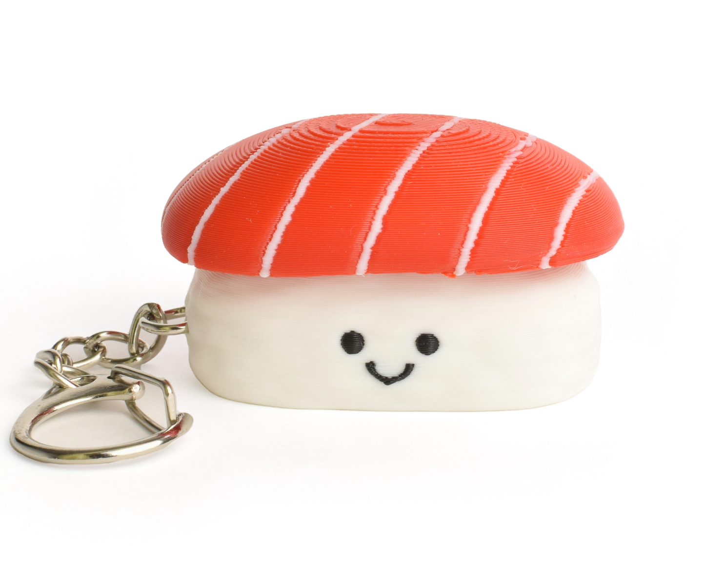 A small sushi-shaped clicker keychain with a smiling face, featuring a tuna top and a white rice base, attached to a silver metal key ring on a plain white background.