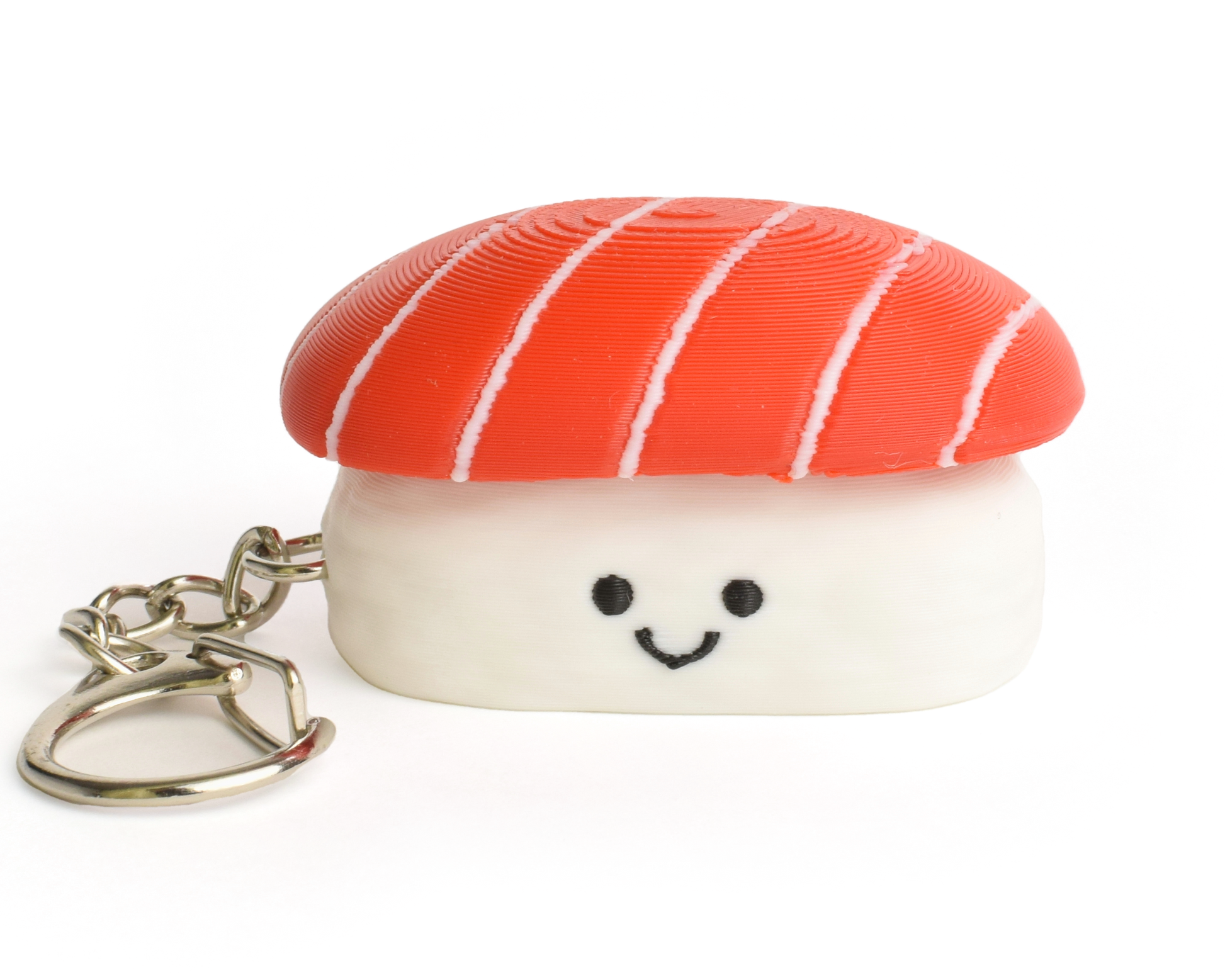 A small sushi-shaped clicker keychain with a smiling face, featuring a tuna top and a white rice base, attached to a silver metal key ring on a plain white background.