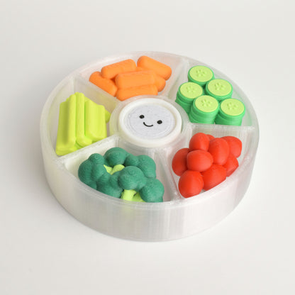 A colorful veggie platter clicker fidget toy with multiple switches (6) and a smiley face on a white background. There are carrots, cucumbers, cherry tomatoes, celery, broccoli, and a dipping sauce.