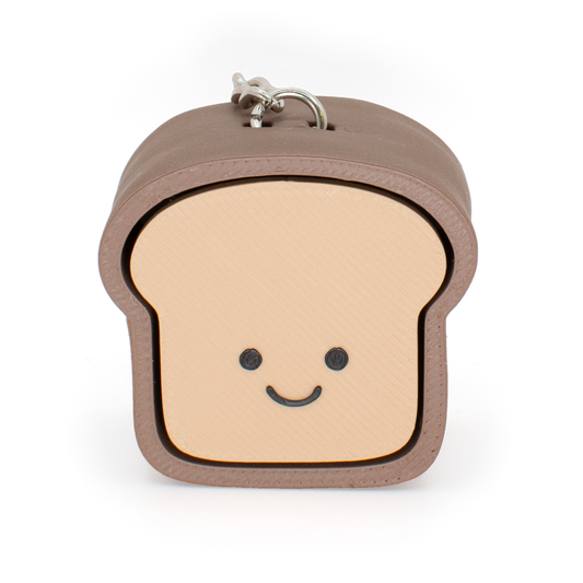 A fidget clicker designed to look like a loaf of bread with a smiling face, primarily in beige and brown colors.